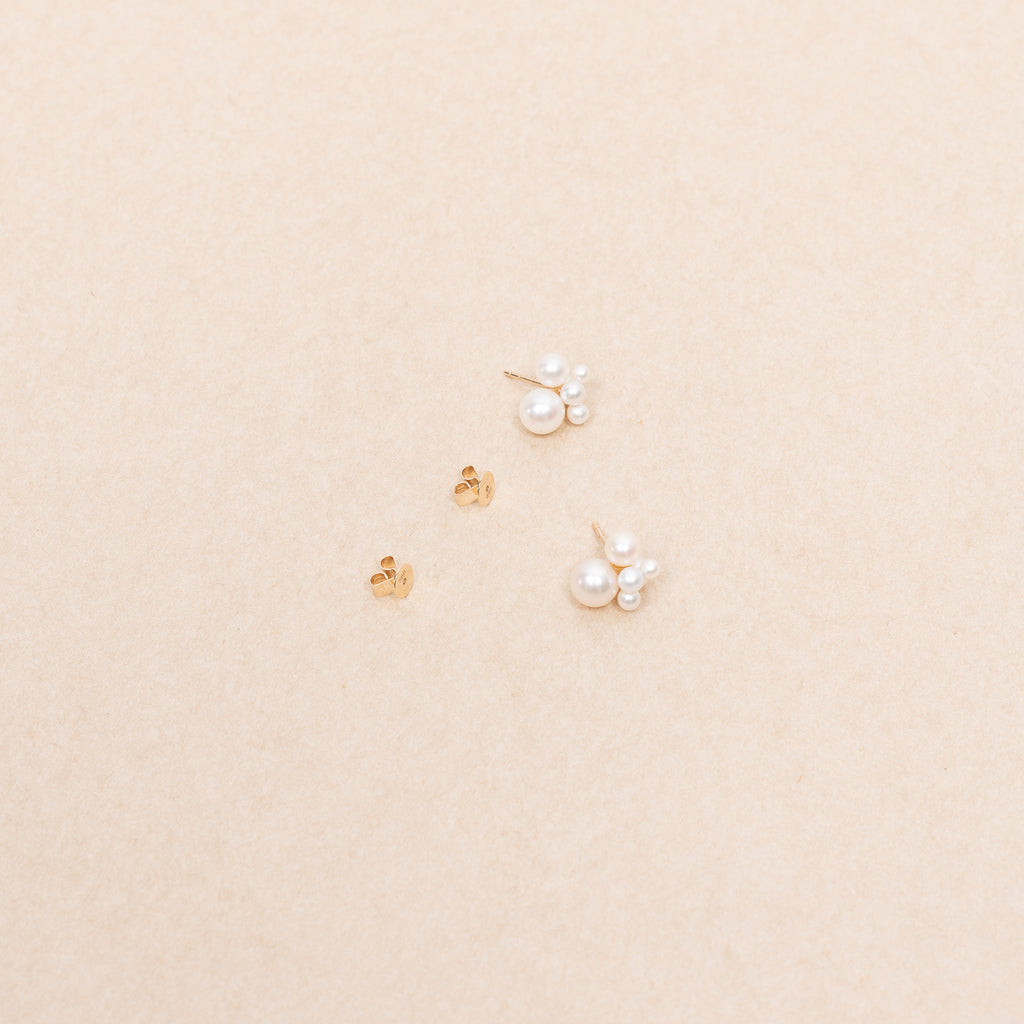 The Bisou Earring by Sophie Bille Brahe is a delicate stud earring in 14 Kt Gold with a small cluster of white freshwater pearls varying in size