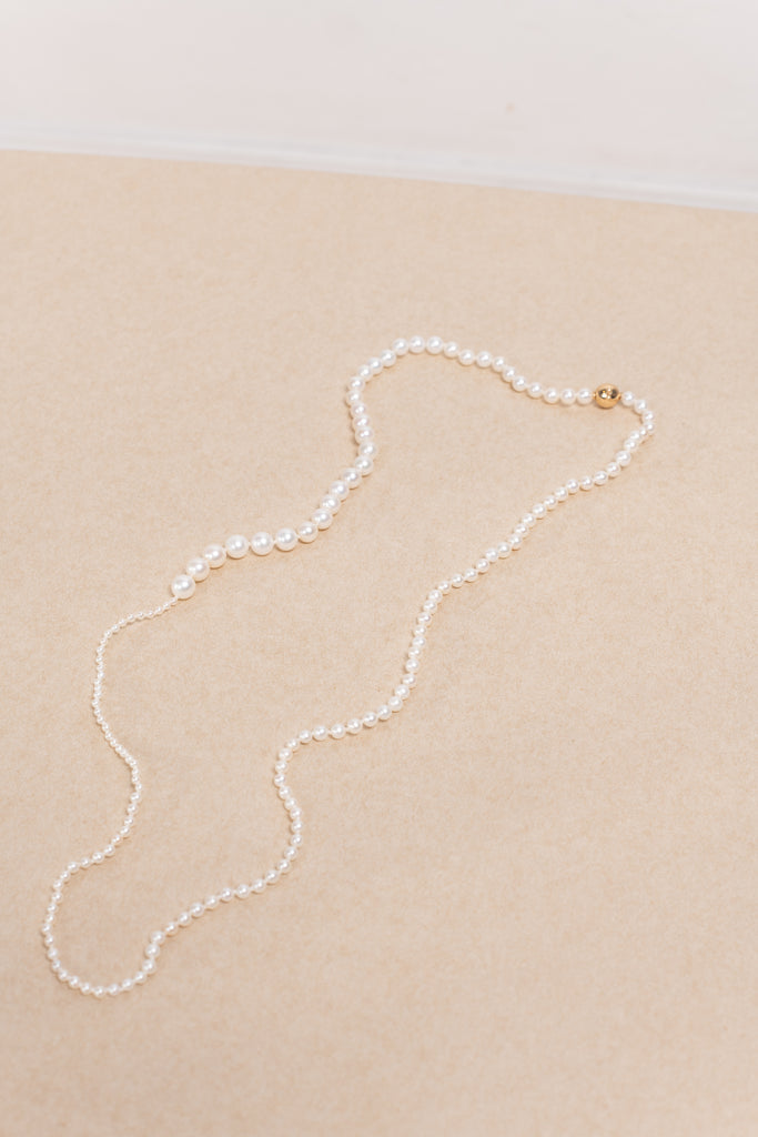 The Petite Peggy Perle Necklace is a longer version of the classic Petite Peggy Necklace with graduating sized Freshwater Pearls on an ancient Gold Lock
