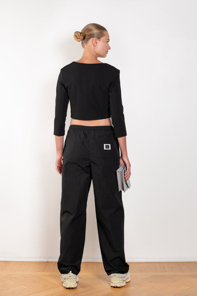 The Face Track Pants 89 by Acne Studios are made from nylon with a textured finish, detailed with a reflective face logo patch
