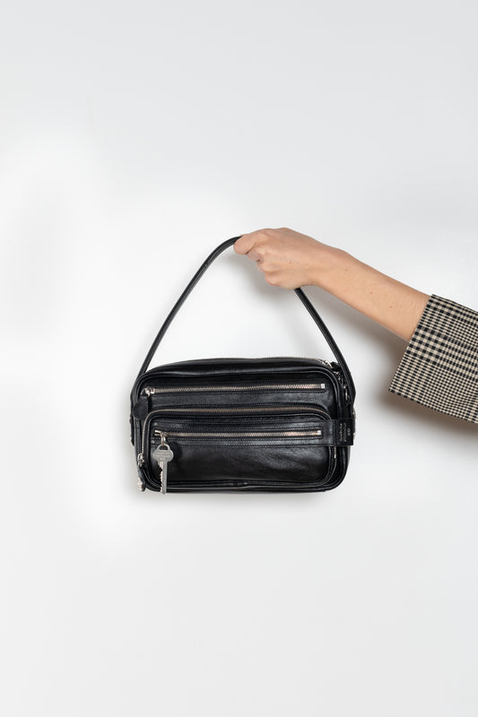 The Camero bag by Acne Studios features a multipocket typology with a soft, rectangular design and a compact, structured silhouette