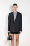 The Pinstripe Jacket by Acne Studios is a double-breasted suit jacket in a wool blend yarn pinstripe woven in a fine herringbone structure and drape finish