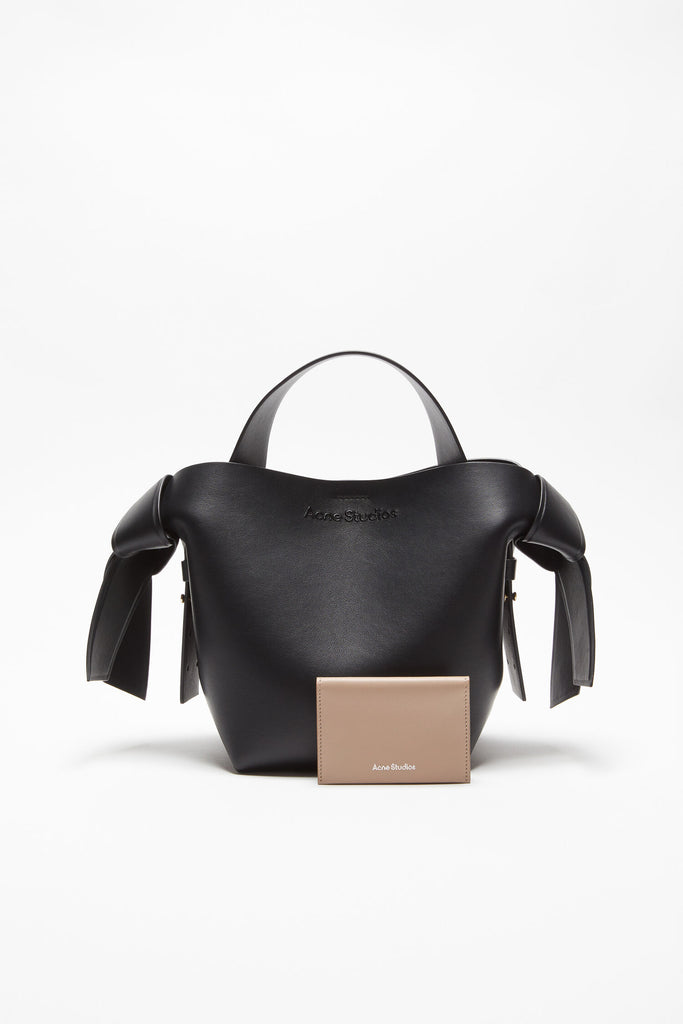 The Folded Leather Wallet by Acne Studios features a folded opening with card slot compartments, crafted from smooth leather and detailed with an Acne Studios logo on the front