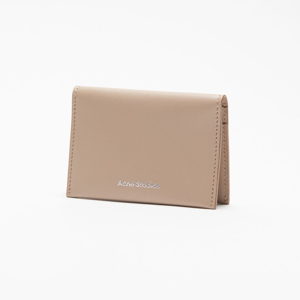 The Folded Leather Wallet by Acne Studios features a folded opening with card slot compartments, crafted from smooth leather and detailed with an Acne Studios logo on the front