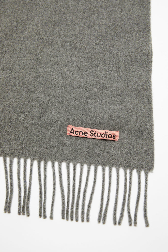 The Oversized Fringed Scarf by Acne Studios is crafted from midweight wool with a soft hand-feel, detailed with a pink Acne Studios label