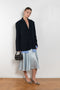 The Silk Wrap Skirt by Acne Studios is a silk A-line skirt with a wrap construction, featuring silver-toned bell and hardware details with a tonal tie-up closure