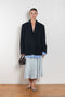The Silk Wrap Skirt by Acne Studios is a silk A-line skirt with a wrap construction, featuring silver-toned bell and hardware details with a tonal tie-up closure