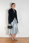 The Silk Wrap Skirt by Acne Studios is a silk A-line skirt with a wrap construction, featuring silver-toned bell and hardware details with a tonal tie-up closure
