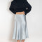 The Silk Wrap Skirt by Acne Studios is a silk A-line skirt with a wrap construction, featuring silver-toned bell and hardware details with a tonal tie-up closure