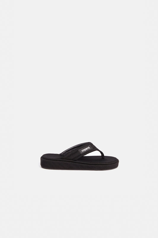 The Branded Flip Flop by Coperni is a signature black sipper sandal covered with satin soles