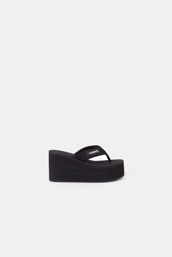 The Branded Wedge Sandal by Coperni is a signature black wedge sandal with lightweight platform soles