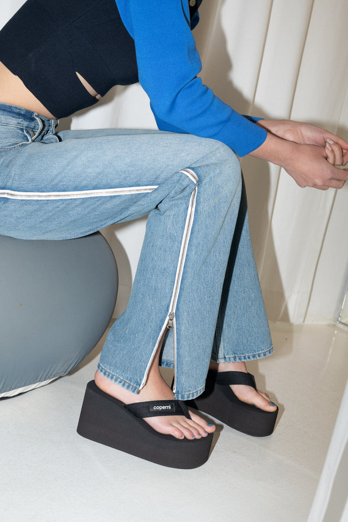 The Branded Wedge Sandal by Coperni is a signature black wedge sandal with lightweight platform soles