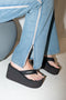 The Branded Wedge Sandal by Coperni is a signature black wedge sandal with lightweight platform soles