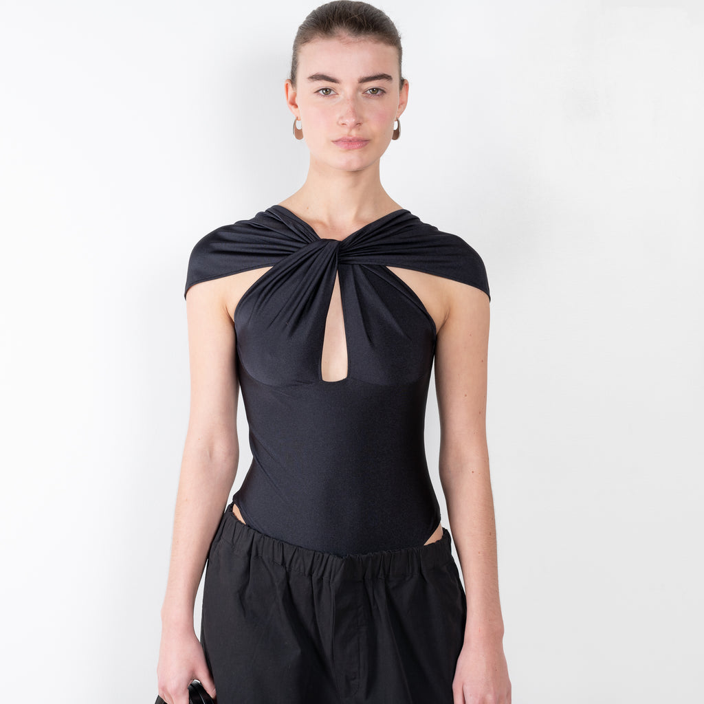 The Cut Out Jersey Bodysuit by Coperni is a signature bodysuit with cut outs and a twisted neckline
