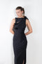 The Asymmetric Flower Gown by Coperni is a signature stretch black dress with cut outs and flower embellishments