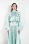 The Tracy Silk Blouse by Julie Kegels is a silk wrap top in aqua with a Hawaïan floral print and contrasting cuffs