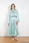 The Tracy Silk Blouse by Julie Kegels is a silk wrap top in aqua with a Hawaïan floral print and contrasting cuffs