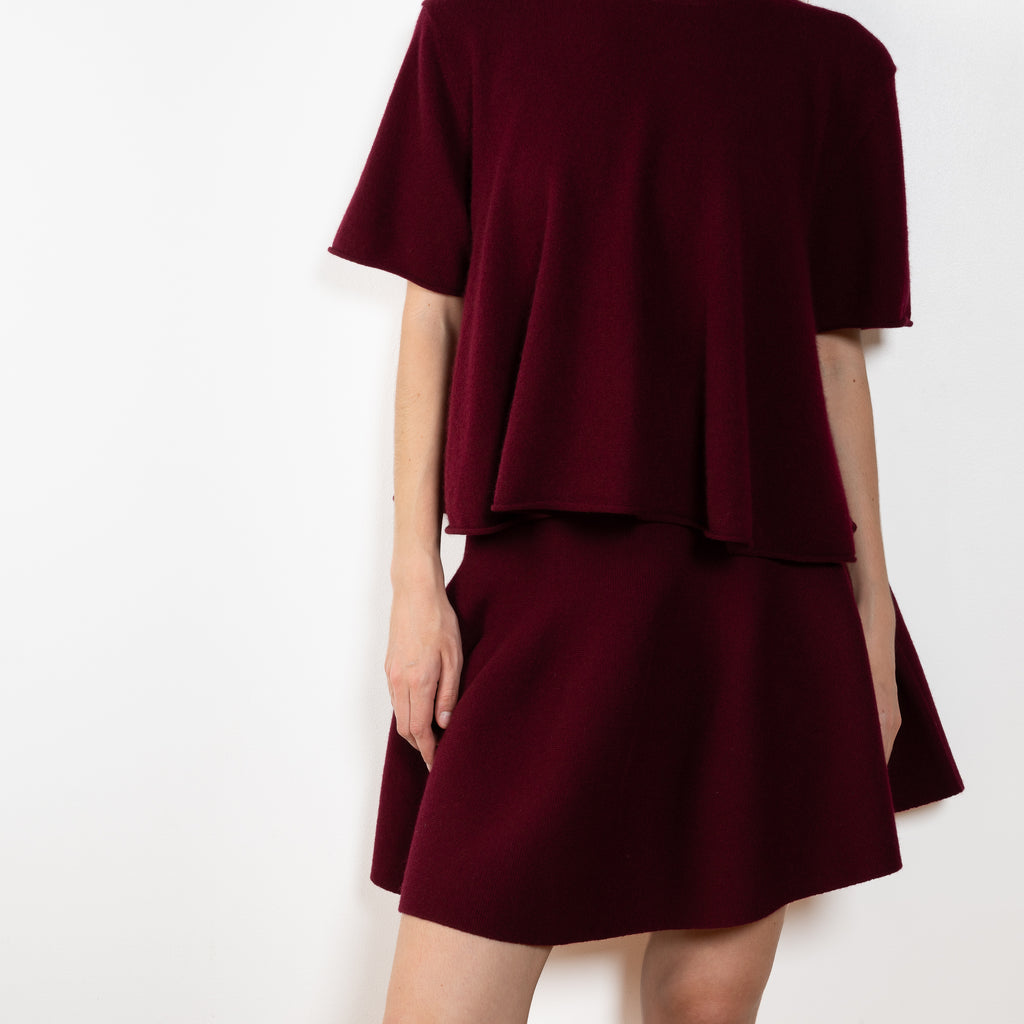 The Liru Tshirt by LISA YANG is knitted in 12-gauge cashmere. The relaxed fit falls from a ribbed round neck into a wide A-line, peplum-inspired shape, complete with dropped shoulders, short sleeves and rolled hems