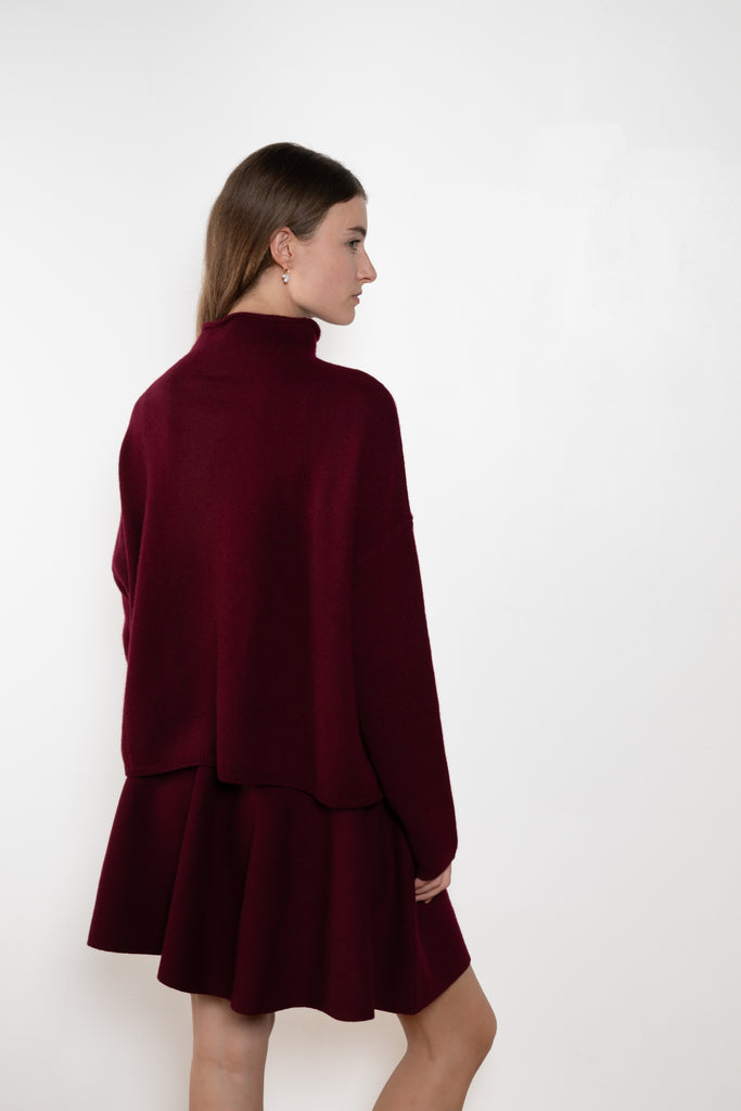 The Sandy Sweater by Lisa Yang has a straight fit with dropped shoulders and a raw hem mock neck.

