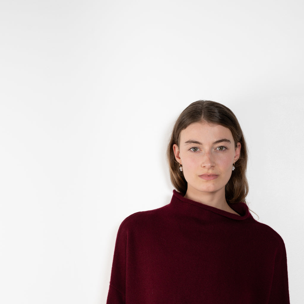 The Sandy Sweater by Lisa Yang has a straight fit with dropped shoulders and a raw hem mock neck.