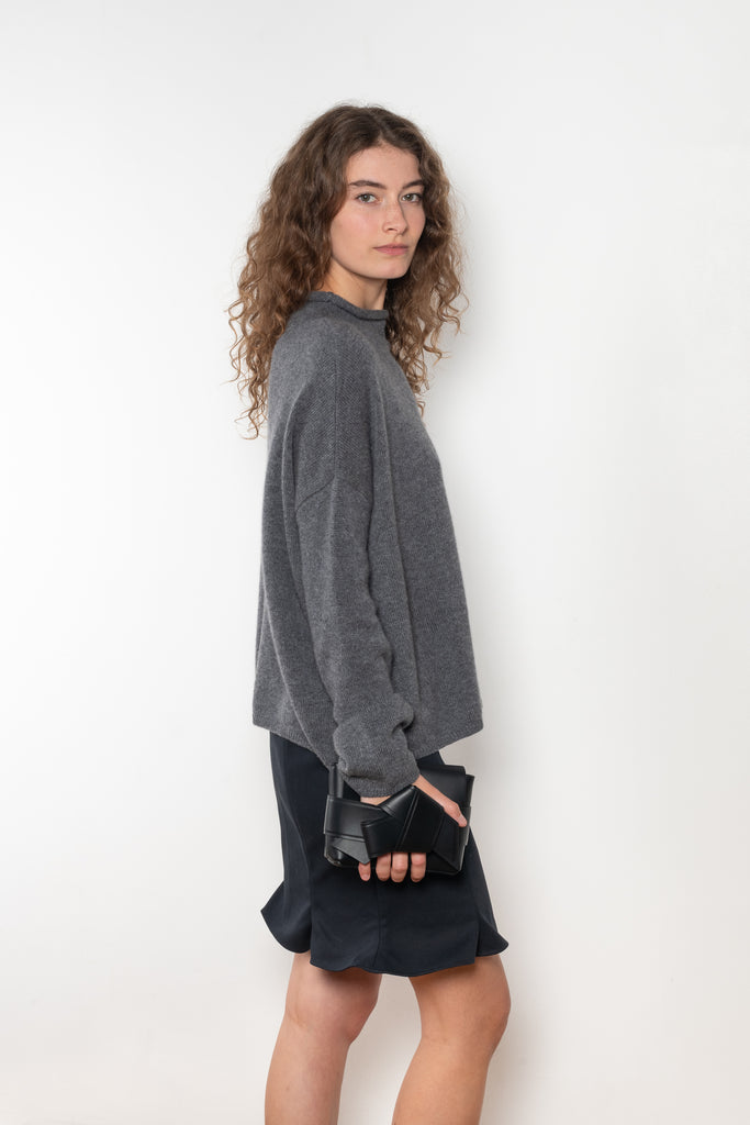 The Sandy Sweater by LISA YANG has a straight fit with dropped shoulders and a raw hem mock neck