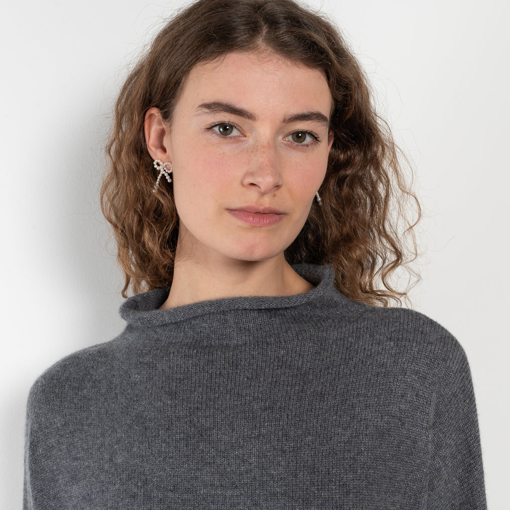 The Sandy Sweater by LISA YANG has a straight fit with dropped shoulders and a raw hem mock neck