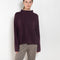 The Sandy Sweater by LISA YANG has a straight fit with dropped shoulders and a raw hem mock neck