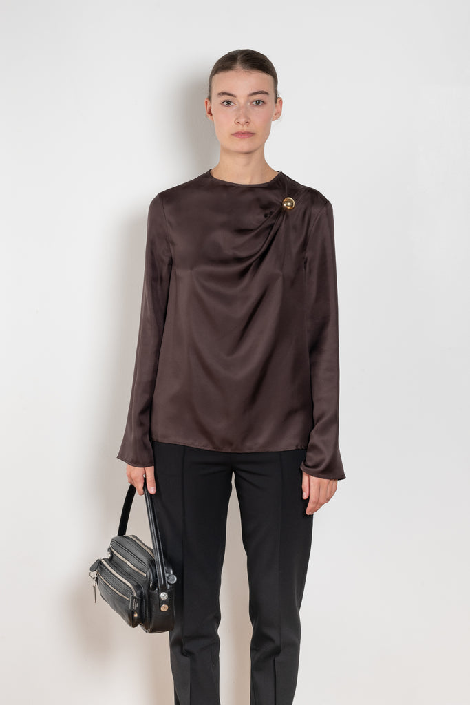 The Azae Blouse by Loulou Studio is a refined silk twill blouse with a draped detail and hardware embellishment