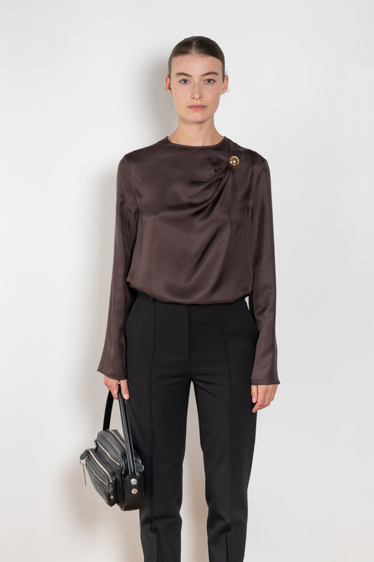 The Azae Blouse by Loulou Studio is a refined silk twill blouse with a draped detail and hardware embellishment
