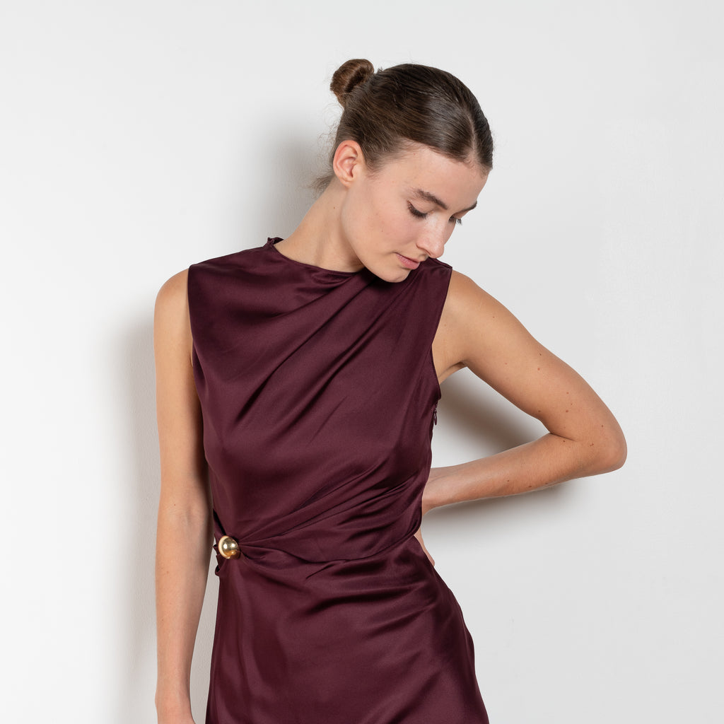 The Roan Dress by Loulou Studio is an elegant evening dress with a draped detail and hardware embellishment in a fluid silk twill