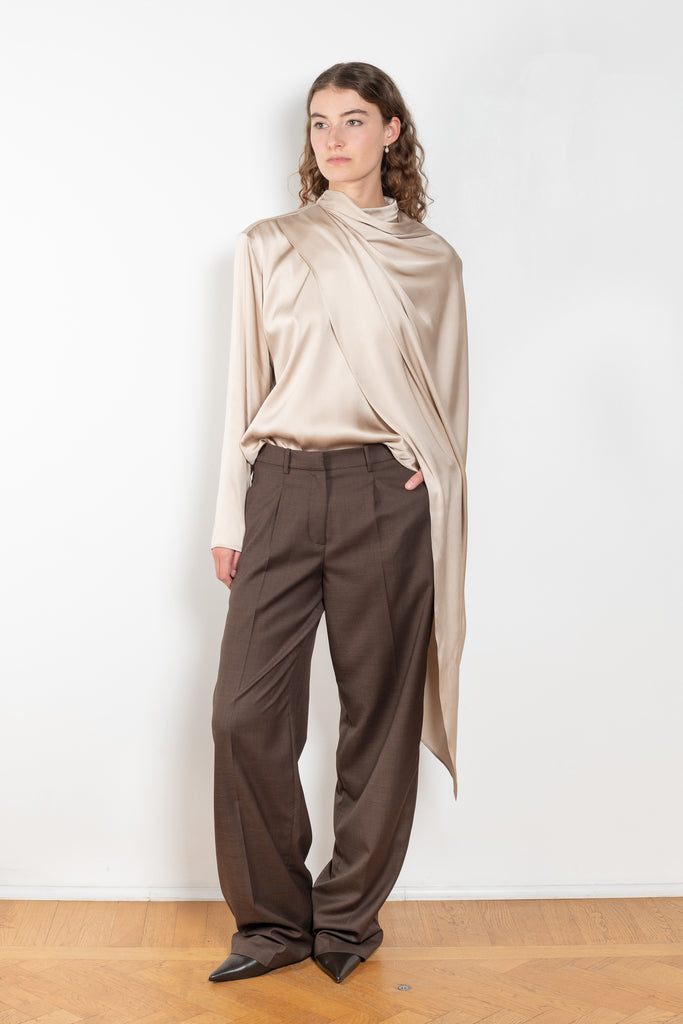The Silk Shirt by Magda Butrym is a long-sleeve silk blouse with a round neck and carefully draped fabric that gives way to a dramatic cape that sweeps off the shoulder