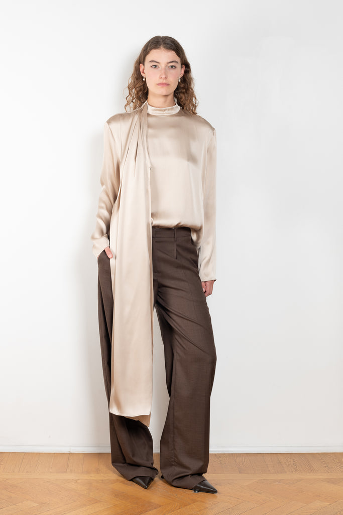 The Silk Shirt by Magda Butrym is a long-sleeve silk blouse with a round neck and carefully draped fabric that gives way to a dramatic cape that sweeps off the shoulder