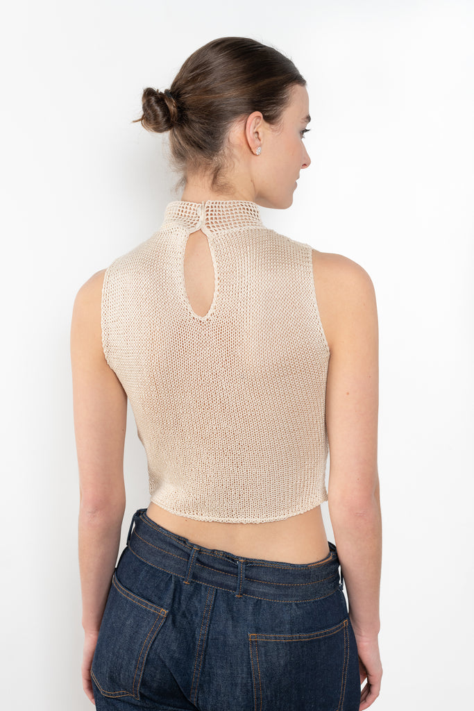 The Crochet Lace Top by Magda Butrym is a cropped top with a high neck and an all-over floral design in traditional Polish crochet technique