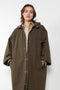 The Parka Coat Oil by Maud Van Den Beussche is a long parka in a structured cotton with detachable hood