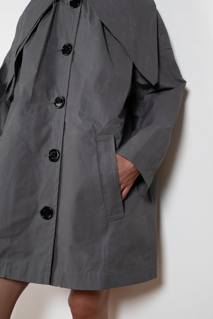 The Bandana Trench by Meryll Rogge is a trench coat crafted in trench cotton, featuring a bandana collar, raglan sleeves and a button closure.
