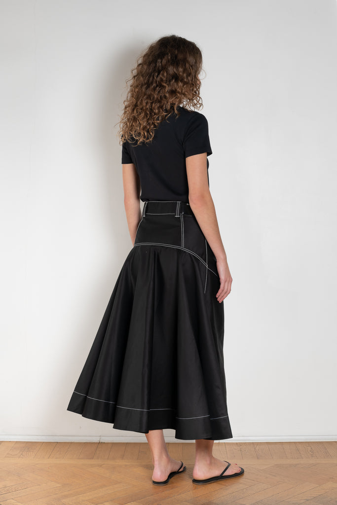 The Flared Workwear Skirt by Meryll Rogge is a long cotton skirt with a flat front and flared fit on the back