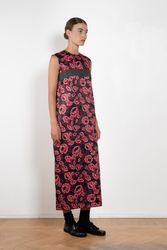 The Long Shift Dress by Meryll Rogge is a sleeveless shift dress crafted in floral scuba satin, featuring a round neckline and a contrasting ribbon detail.