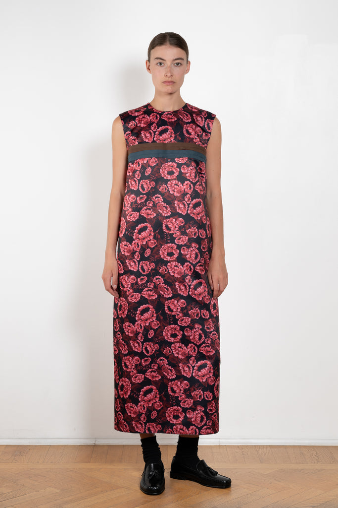 The Long Shift Dress by Meryll Rogge is a sleeveless shift dress crafted in floral scuba satin, featuring a round neckline and a contrasting ribbon detail.