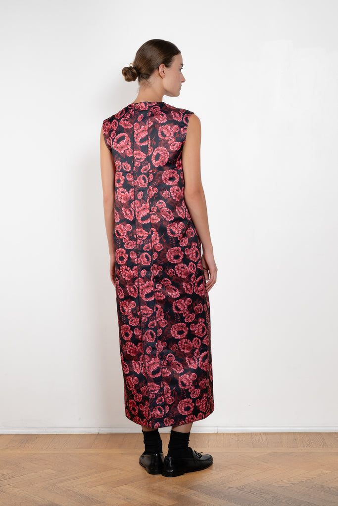 The Long Shift Dress by Meryll Rogge is a sleeveless shift dress crafted in floral scuba satin, featuring a round neckline and a contrasting ribbon detail.