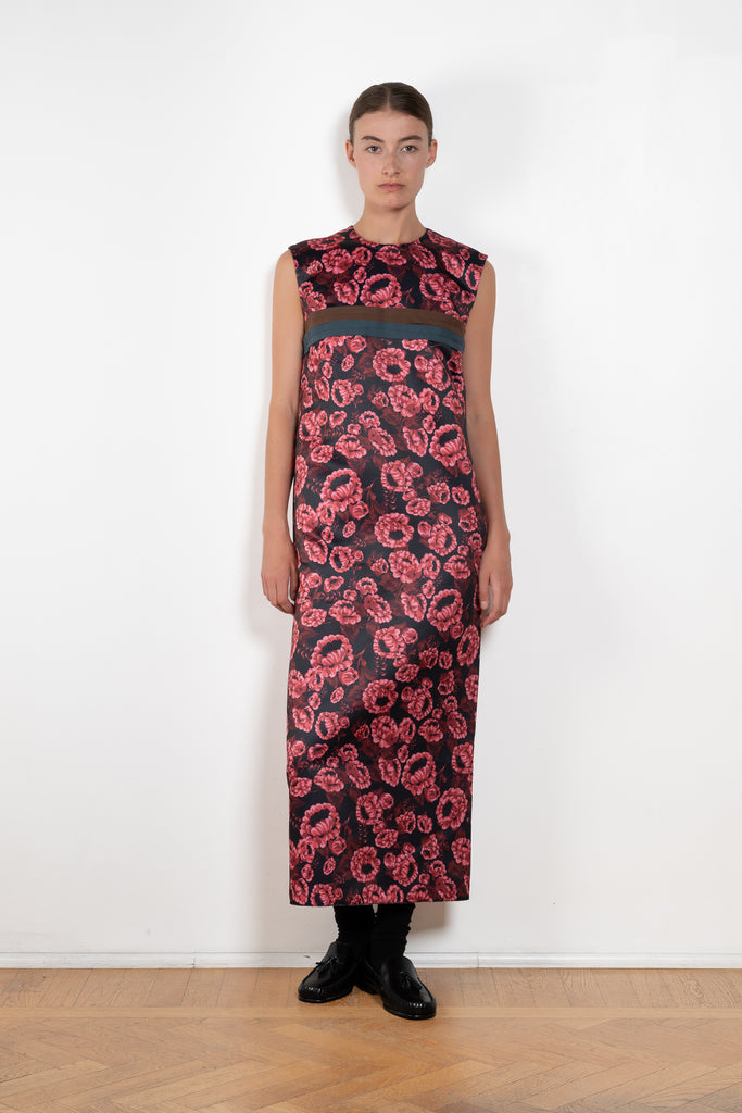The Long Shift Dress by Meryll Rogge is a sleeveless shift dress crafted in floral scuba satin, featuring a round neckline and a contrasting ribbon detail.