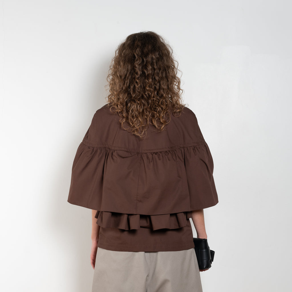 The Ruffle Tiered Top by Meryll Rogge is a crisp cotton top with layered ruffles that can be tucked into your trousers