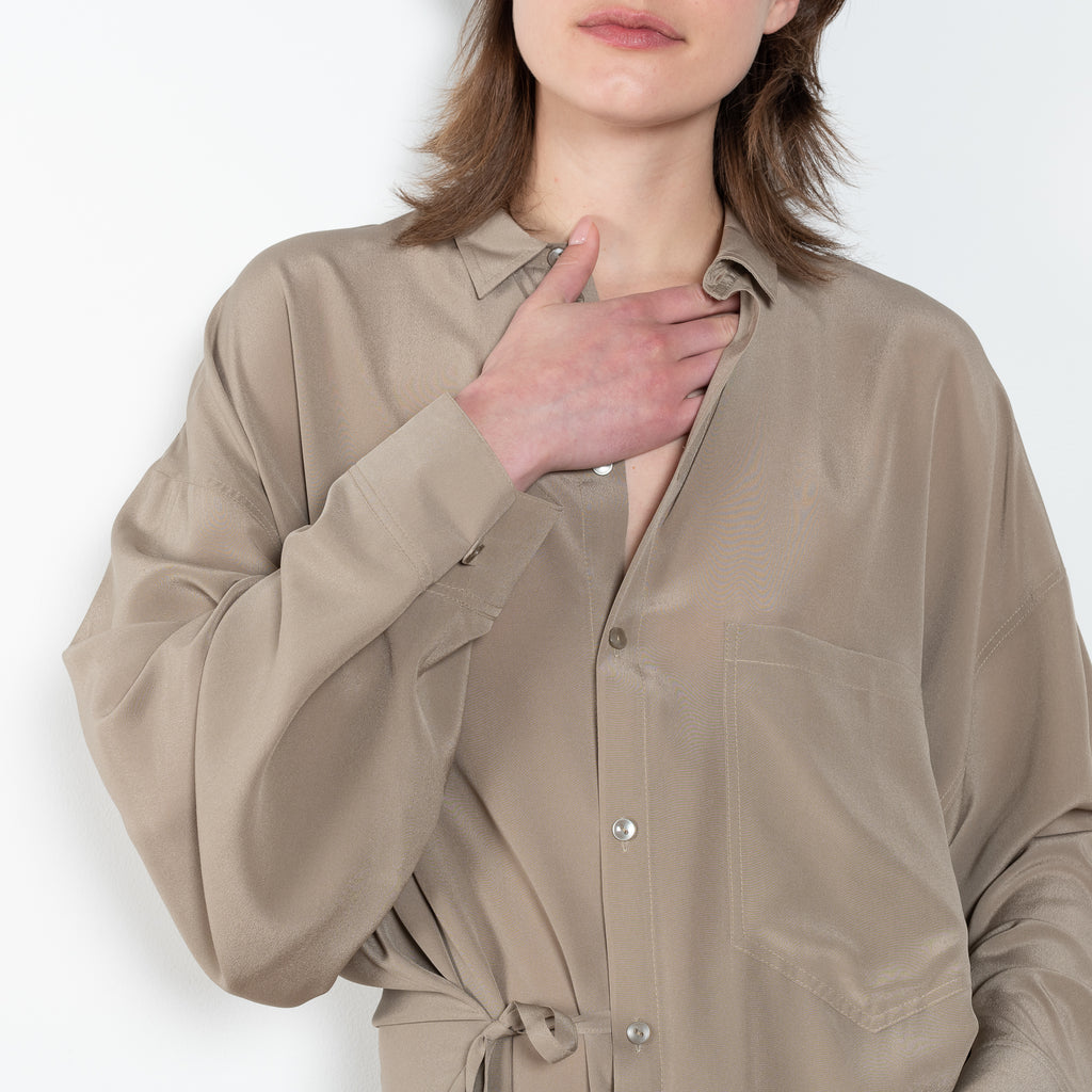 The 10.4 Dress by Monique Van Heist is a loose silk dress that can be tied at the waist