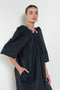 The Grand Bazaar Dress by Nackiye is a signature dress with shawl shoulder feature, two pockets, front slit and a belt, and the classic double pearl neck pin 