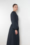 The Grand Bazaar Dress by Nackiye is a signature dress with shawl shoulder feature, two pockets, front slit and a belt, and the classic double pearl neck pin 