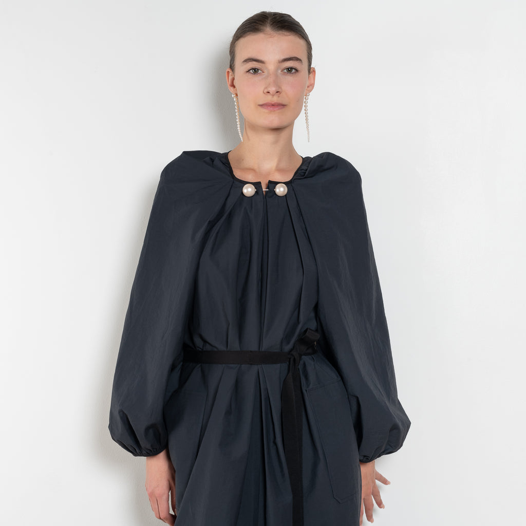 The Grand Bazaar Dress by Nackiye is a signature dress with shawl shoulder feature, two pockets, front slit and a belt, and the classic double pearl neck pin&nbsp;