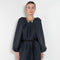 The Grand Bazaar Dress by Nackiye is a signature dress with shawl shoulder feature, two pockets, front slit and a belt, and the classic double pearl neck pin&nbsp;