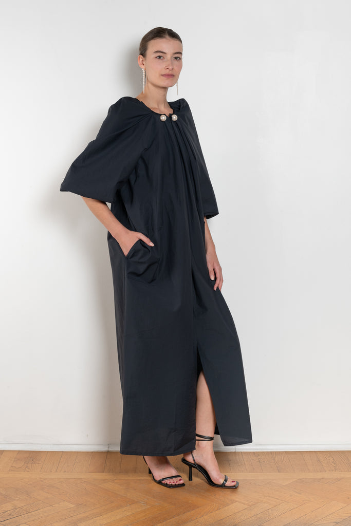 The Grand Bazaar Dress by Nackiye is a signature dress with shawl shoulder feature, two pockets, front slit and a belt, and the classic double pearl neck pin 