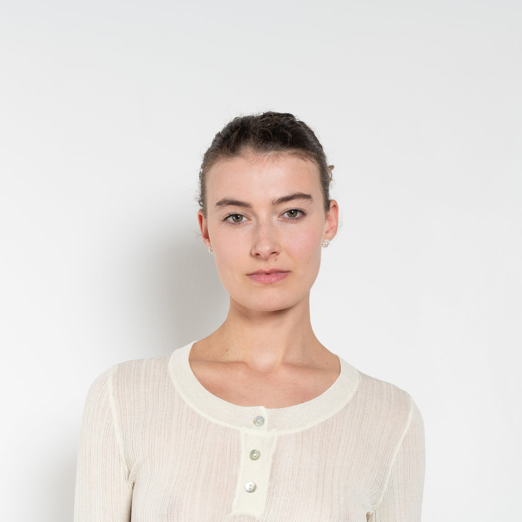 The Keep Close Top is a tightly ribbed buttoned Henley crew neck