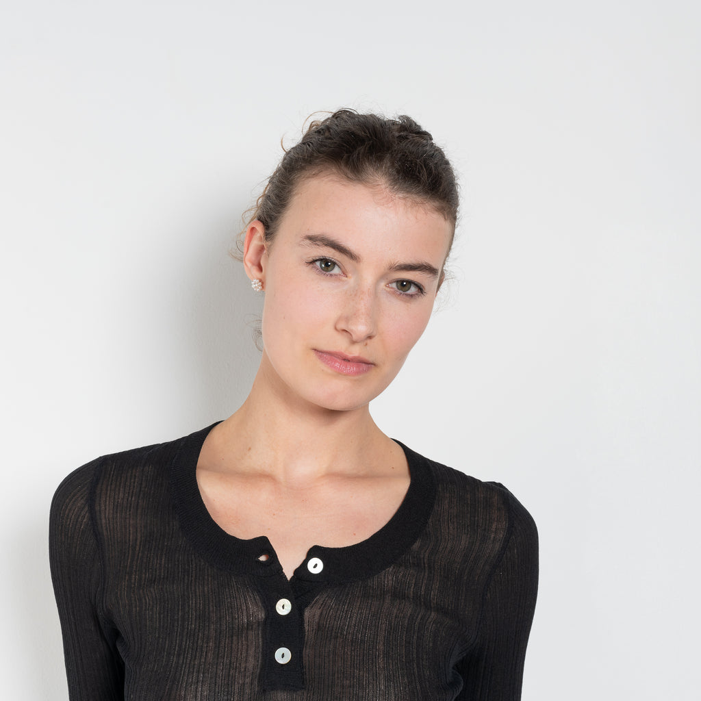The Keep Close Top is a tightly ribbed buttoned Henley crew neck