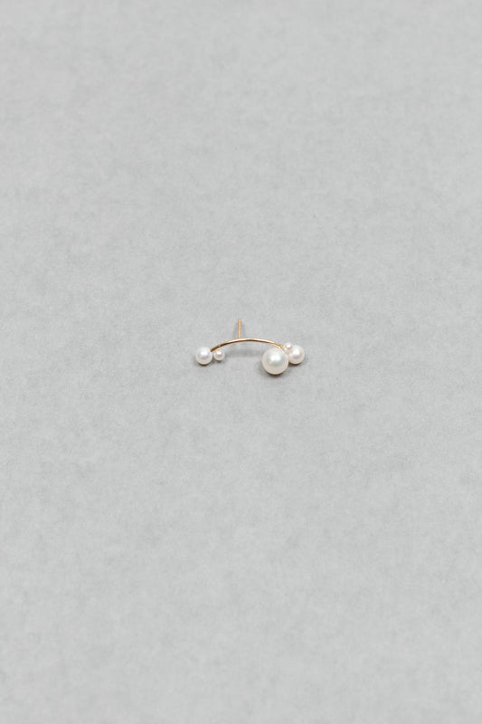 The Stellari Right by Sophie Bille Brahe is a petite version of the Stellari Perle earring with pearls in various sizes placed on a curved gold stem