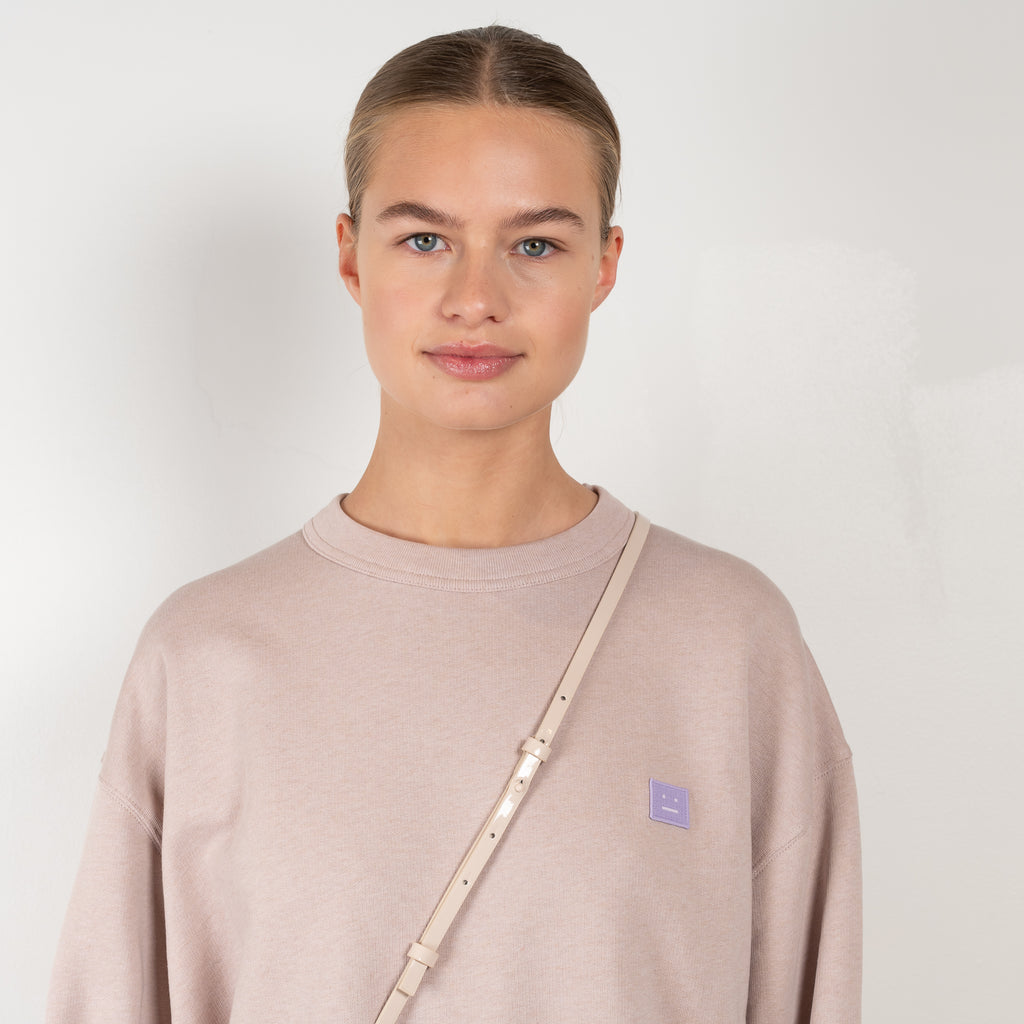 The Face Sweater 156 by Acne Studios is an oversized crew neck sweater with a face logo patch on the chest and ribbed cuffs and hem